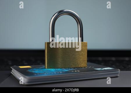 Cybersicherheit. Metallschloss und Kreditkarten auf Laptop, Nahaufnahme Stockfoto