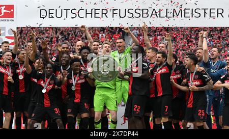 LEVERKUSEN - Bayer 04 Leverkusen Coach Kovar, Noah Mbamba, Nathan Tella, Alejandro Grimaldo, Amine Adli, Victor Boniface, Adam Hlozek, Timothy Fosu Mensah, Exequiel Palacios, Torhüter Patrick Pentz, JEREMIE Frimpong, Madi Monamay, Gustavo Puerta, Granit Xhaka, Torhüter Niklas Lomb, Ken Izekor, Torhüter Jesper schlich, Francis Onyeka, Noah Pesch, Daniel lang, Torhüter Luca Novodomsky, Ayman Aourir feiern den Sieg der Meisterschaft und der Deutschen Meisterschale beim Bundesliga-Spiel zwischen Bayer 04 Leverkusen und dem FC Augsburg am 18. Mai 2024 in der DE Bay Arena in Leverkusen Stockfoto