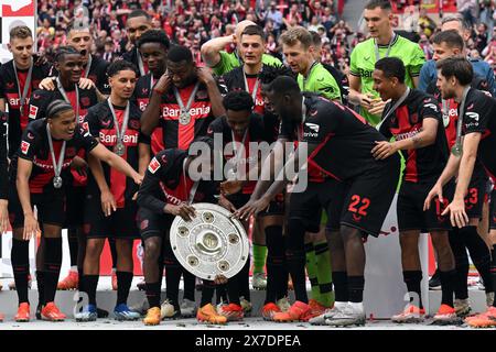 LEVERKUSEN - Bayer 04 Leverkusen Coach Kovar, Noah Mbamba, Nathan Tella, Alejandro Grimaldo, Amine Adli, Victor Boniface, Adam Hlozek, Timothy Fosu Mensah, Exequiel Palacios, Torhüter Patrick Pentz, JEREMIE Frimpong, Madi Monamay, Gustavo Puerta, Granit Xhaka, Torhüter Niklas Lomb, Ken Izekor, Torhüter Jesper schlich, Francis Onyeka, Noah Pesch, Daniel lang, Torhüter Luca Novodomsky, Ayman Aourir feiern den Sieg der Meisterschaft und der Deutschen Meisterschale beim Bundesliga-Spiel zwischen Bayer 04 Leverkusen und dem FC Augsburg am 18. Mai 2024 in der DE Bay Arena in Leverkusen Stockfoto