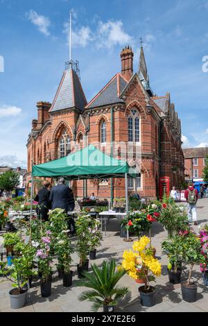 Wokingham Town Hall im Stadtzentrum von Berkshire, England, Großbritannien, mit einem Marktstand, an dem Blumen verkauft werden Stockfoto