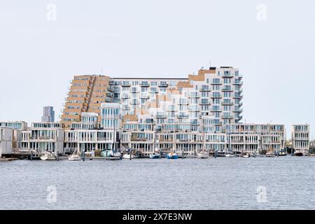 Niederlande, Amsterdam - 6. April 2024: Sluishuis modernes Wohngebäude im Stadtteil Ijburg, entworfen von Bjarke Ingels Group, GROSS Stockfoto