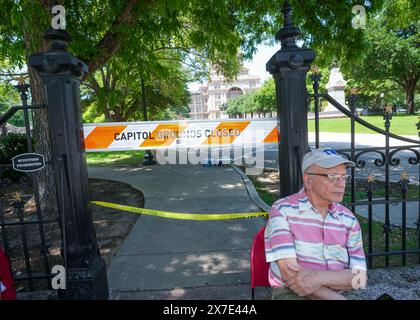 Austin, Texas, USA, 19. Mai 2024: Ein Mann sitzt am abgesperrten Eingang zum Texas Capitol. Pro-palästinensische Demonstranten, die eine Kundgebung auf dem Kapitolgelände geplant hatten, marschierten stattdessen durch die Innenstadt, nachdem Gouverneur Greg Abbott in seltenen Schritten das Kapitolgelände geschlossen hatte, weil er Angst vor Gewalt hatte. Quelle: Bob Daemmrich/Alamy Live News Stockfoto