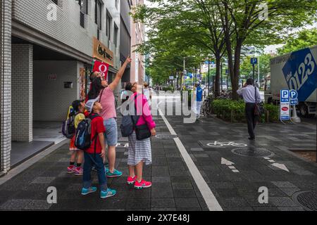 Kyoto, JAPAN - 27. Juli 2016: Asiatische Familie blickt auf dem Fußgängerweg in den Himmel. Stockfoto