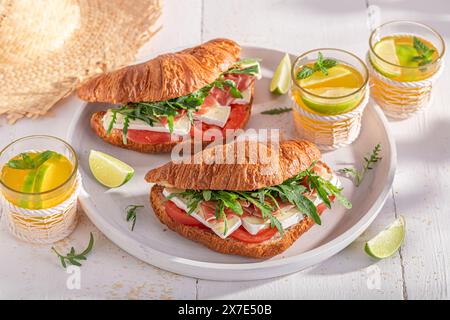 Gesundes und heißes französisches Croissant aus Blätterteig. Sandwich mit Schinken, Käse und Gemüse. Stockfoto