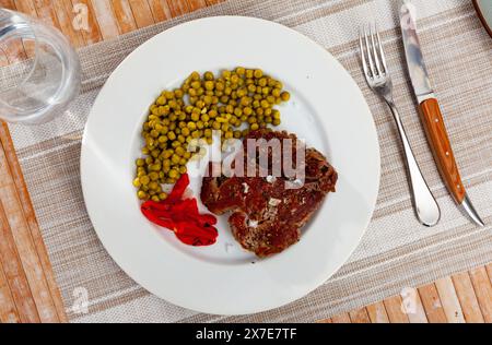 Ganzes Rindfleisch über offenem Feuer gekocht, mit appetitlicher Kruste und dunklen Streifen mit Paprika, Bohnen Stockfoto