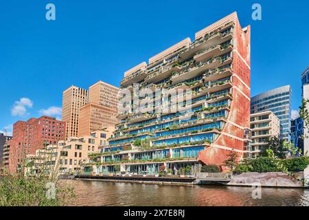 Niederlande, Amsterdam - 10. April 2024: Zuidas's außergewöhnliches Terrassenwohnhaus The George mit bepflanzten Balkonen Stockfoto