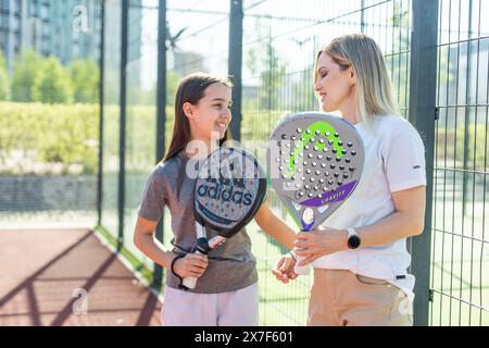 Ukraine, Kiew, 03. Mai 2024, Mutter und Tochter mit Kopf- und Adidas-Schlägern Stockfoto