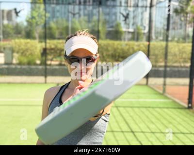 Frauen, die Ball servieren. Junge Erwachsene Mädchen spielen Tennis vor der Arena. Person Racket Beat Game Club. People Group hat das Spiel auf dem Sportplatz getroffen. Pflege der Passform Stockfoto