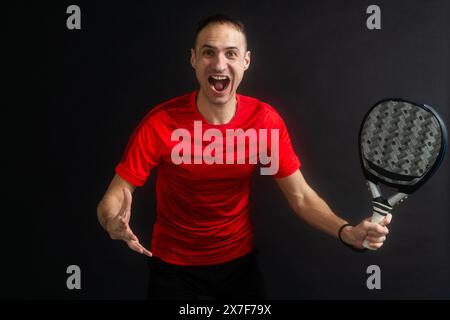 Lächelnder Mann mit Schläger und Paddelball in Sportkleidung gekleidet isolierter Hintergrund. Vorderansicht. Stockfoto