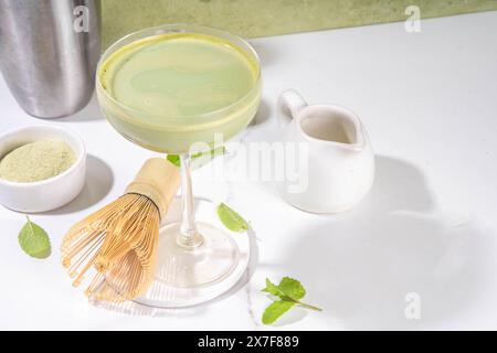 Cremiger Matcha-Martini-Cocktail Matchatini, trendiger kalter Sommercocktail. Matcha alkoholfreier Mocktail oder Alkohol Cocktail, in Martini Gläsern mit GREE Stockfoto