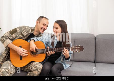 Ein Veteran und seine Tochter spielen Gitarre Stockfoto