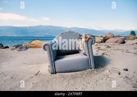 Verlassener, abgenutzter, alter und dreckiger Sessel am Strand. Stockfoto