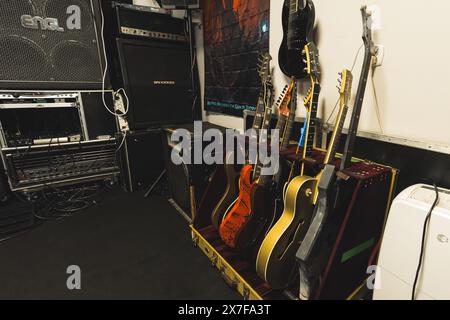 Blick auf verschiedene Farbgitarren, Verstärker und Lautsprecher im Musikstudio, Ausstattung des Proberaums. Hochwertige Fotos Stockfoto