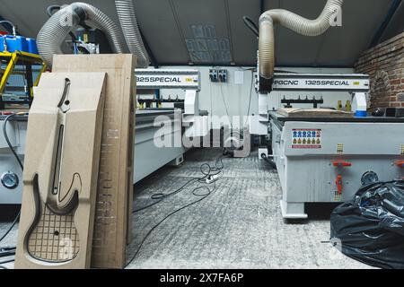 15.04.2024. Warschau, Polen. Werkstatt für die Gitarrenproduktion, MDF-Boardformen zur Herstellung von elektrischen Gitarren, Fräsmaschinen im Hintergrund. Hochwertige 3D-Illustration Stockfoto