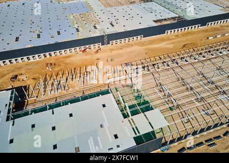 Luftaufnahme der Baustelle mit im Bau befindlichem Lagergebäude zur Lagerung. Montage von Industriebauten mit Stahlrahmenkonstruktion und Stockfoto