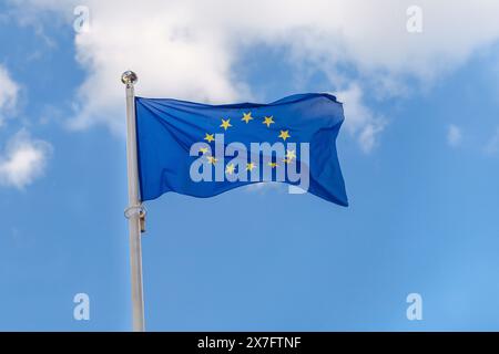 Die Europäische Union fliegt vor dem Hintergrund eines bewölkten blauen Himmels unter der Flagge der EU Stockfoto