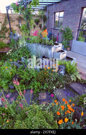 London, Großbritannien. Mai 2024. Eröffnungstag bei der Royal Horticultural Society Chelsea Flower Show 2024 - einer der Sanctuary Gardens auf der Ausstellung: The Flood Re: The Flood Resilient Garden der Garten ist so gestaltet, dass er schön und angenehm ist, während er gleichzeitig das Hochwasserrisiko reduziert und sich nach starkem Regen schnell erholt. Das dichte Pflanzen verlangsamt den Wasserfluss, fängt es auf und speichert es für den späteren Gebrauch. Ein erhöhtes Deck und ein Hügel, verbunden durch eine Brücke über eine zentrale Talsohle, bieten bewohnbare Räume und gut durchlässigen Boden. Quelle: Michael Preston/Alamy Live News Stockfoto