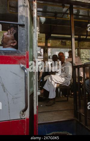 Indien, New Dehli - 24 10 2017: Indische Männer sitzen im Bus. Schlafender Mann und Fahrgäste im Bus. Stadtverkehr in Indien. Indische Kultur. Stockfoto