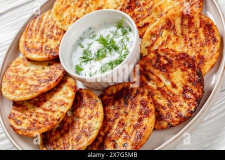 Glutenfreie proteinreiche herzhafte Hüttenkäse Parmesan und Dillpfannkuchen auf Teller mit Sauerrahm, Nahaufnahme Stockfoto