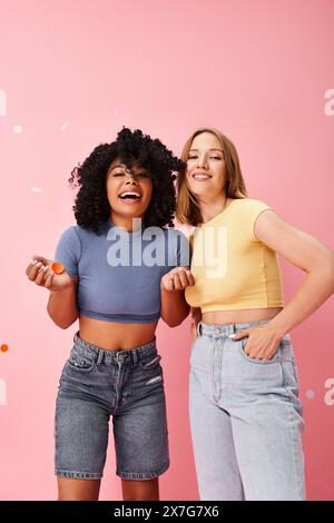 Zwei verschiedene Frauen stehen selbstbewusst vor einer leuchtend rosa Wand. Stockfoto