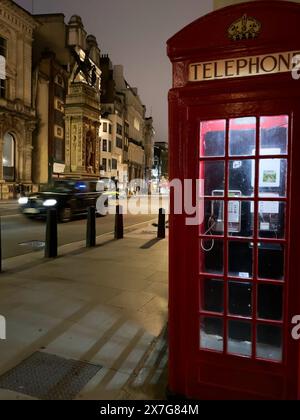 London, Großbritannien. April 2024. Ein Auto fährt an einer roten Telefonzelle vorbei. Quelle: Benedikt von Imhoff/dpa/Alamy Live News Stockfoto