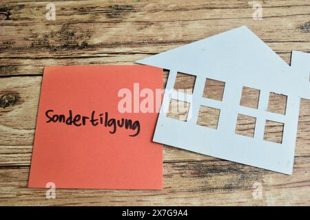 Konzept des Lernens von Sprache - Deutsch. Sondertilgung bedeutet Sonderrückzahlung auf Haftnotizen. Deutsche Sprache isoliert auf Holztisch. Stockfoto