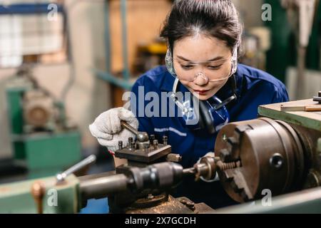 Professioneller Ingenieur Arbeiter mit Sicherheitsaugenschutz Fokus, der in Metalldrehmaschine Fräsmaschine Schwerindustriefabrik arbeitet. Stockfoto