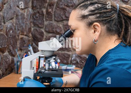 Nachwuchswissenschaftlerin, die mit Mikroskop arbeitet und Analysen und Forschungsarbeiten im Labor macht. Medizinische Gesundheitstechnologie, Biotechnologie Stockfoto