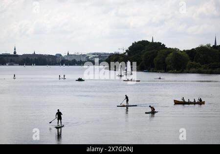 Hamburg, Deutschland. Mai 2024. Wassersportler mit Kanus, Stand-Up-Paddelbrettern (SUP) und Segelbooten sind auf der Alster unterwegs. Quelle: Christian Charisius/dpa/Alamy Live News Stockfoto