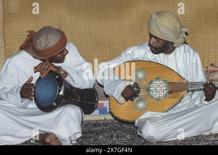 Wahiba Sands, Oman, Arabische Halbinsel, Naher Osten. Omanische Musiker, einer spielt Oud (das Saiteninstrument), der andere eine Trommel, die Tabla genannt wird. Stockfoto