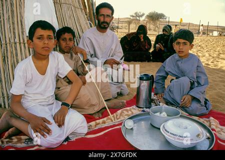 Wahiba Sands, Oman, Arabische Halbinsel, Naher Osten - Eine beduinenfamilie. Der Vater und die beiden Söhne tragen den traditionellen arabischen Mantel, eine Dschungdasha. Stockfoto