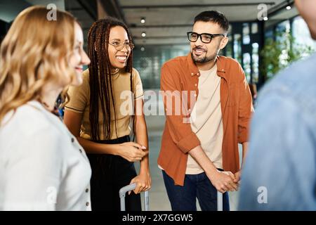 Multikulturelle Kollegen in lässiger Kleidung stehen im Kreis, vertieft in Gespräche in einer Hotellobby während einer Geschäftsreise. Stockfoto