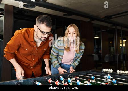 Ein Mann und eine Frau beteiligen sich energisch an einem Spiel und zeigen Teamarbeit und Kameradschaft in einem modernen Coworking-Raum. Stockfoto