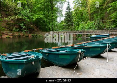 Eine Reihe grüner Kanus ist an einem Pier angedockt. Die Szene ist friedlich und ruhig, die Boote ruhen auf dem Dock und das Wasser in der Nähe. Die Boote sind A Stockfoto