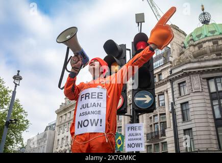 Ein Demonstrant in einem orangefarbenen Kesselanzug hält ein Megaphon, als er die Freilassung des Wikileaks-Gründers Julian Assange aus dem Gefängnis fordert. Stockfoto