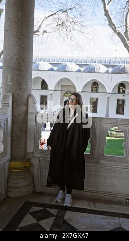 Lächelnde Frau in lässiger Kleidung, die den historischen topkapi-Palast in istanbul, türkei, erkundet. Stockfoto