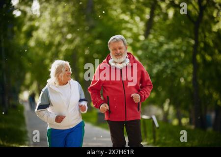 Älteres Paar, Joggen zusammen im ruhigen Park am frühen Sommermorgen, Mann und Frau machen jeden Morgen Routine Stockfoto
