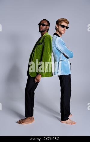 Zwei verschiedene Männer stehen selbstbewusst nebeneinander in stilvoller Pose. Stockfoto
