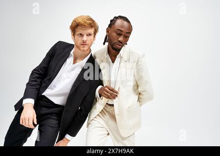 Zwei multikulturelle Männer in scharfen Anzügen, die selbstbewusst posieren. Stockfoto