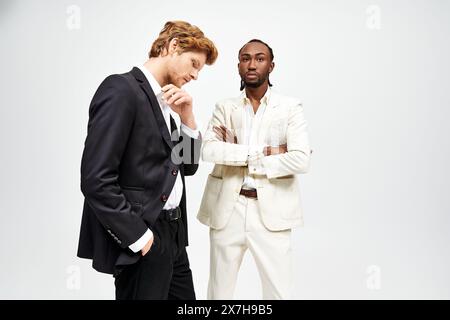 Zwei elegante, multikulturelle Männer in scharfen Anzügen posieren zusammen. Stockfoto