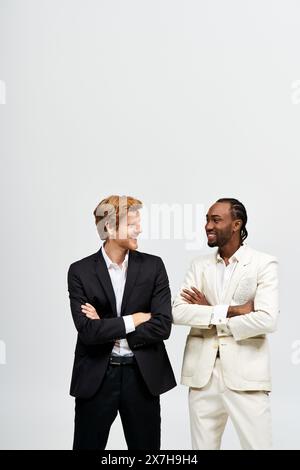 Zwei gutaussehende Männer in Anzügen posieren elegant zusammen. Stockfoto