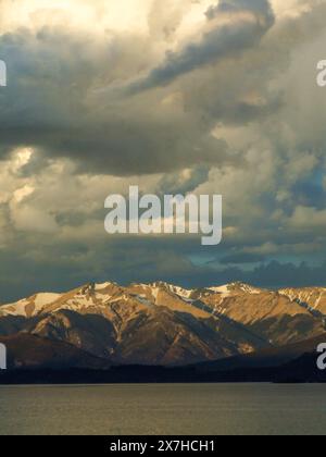Cumulus Wolken am späten Nachmittag über den schneebedeckten Anden über dem See Nahuel Huapi im Nahuel Huapi Nationalpark in Argentinien. Stockfoto