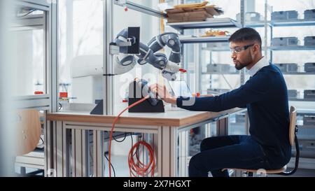 Konzentrierter Engineer Drehregler und Schreiben von Code bei der Entwicklung des Programms für autonomen Arm im Labor des Robotics Research Center. Optimierung und maschinelles Lernen. Stockfoto