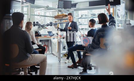 Office Conference Room Meeting: Black weibliche Entwicklerin macht Robotik Industry Präsentation vor einem multiethnischen Team von Geschäftsleuten, in dem die Arbeitsgrundsätze für Roboterarme erläutert werden. Stockfoto