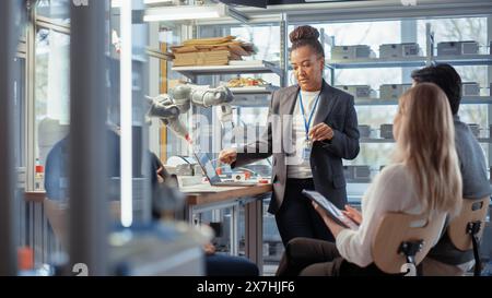 Team-Meeting von Ingenieuren, die an innovativen, effizienteren Methoden für die Anwendung von Roboterarmen arbeiten. Gruppe von Spezialisten versammelte sich um den Tisch, Probleme lösen, Ergebnisse diskutieren. Stockfoto