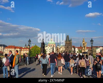 Prag, Tschechische Republik - 10. Mai 2024: Touristen spazieren an einem sonnigen Tag auf der Karlsbrücke. Stockfoto