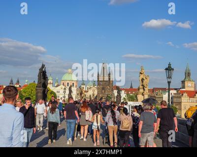 Prag, Tschechische Republik - 10. Mai 2024: Touristen spazieren an einem sonnigen Tag auf der Karlsbrücke. Stockfoto