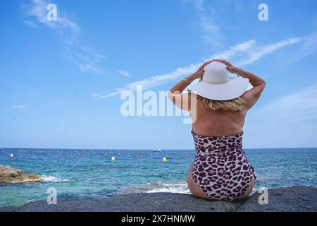 Rückansicht eines erwachsenen weiblichen Touristen im Bikini mit Blick auf das Meer. Sommerzeit in den Ferien Stockfoto