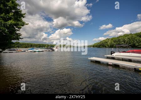 Die Sonne scheint auf einem ruhigen Dock, während die Boote im rauschenden Wasser des Deep Creek Lake im ländlichen Garrett County, Maryland, USA, schweigen. Stockfoto