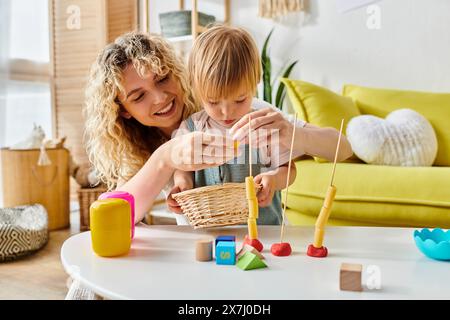 Eine Frau und ein Kind, die sich zu Hause glücklich mit der Montessori-Methode der Erziehung beschäftigen. Stockfoto